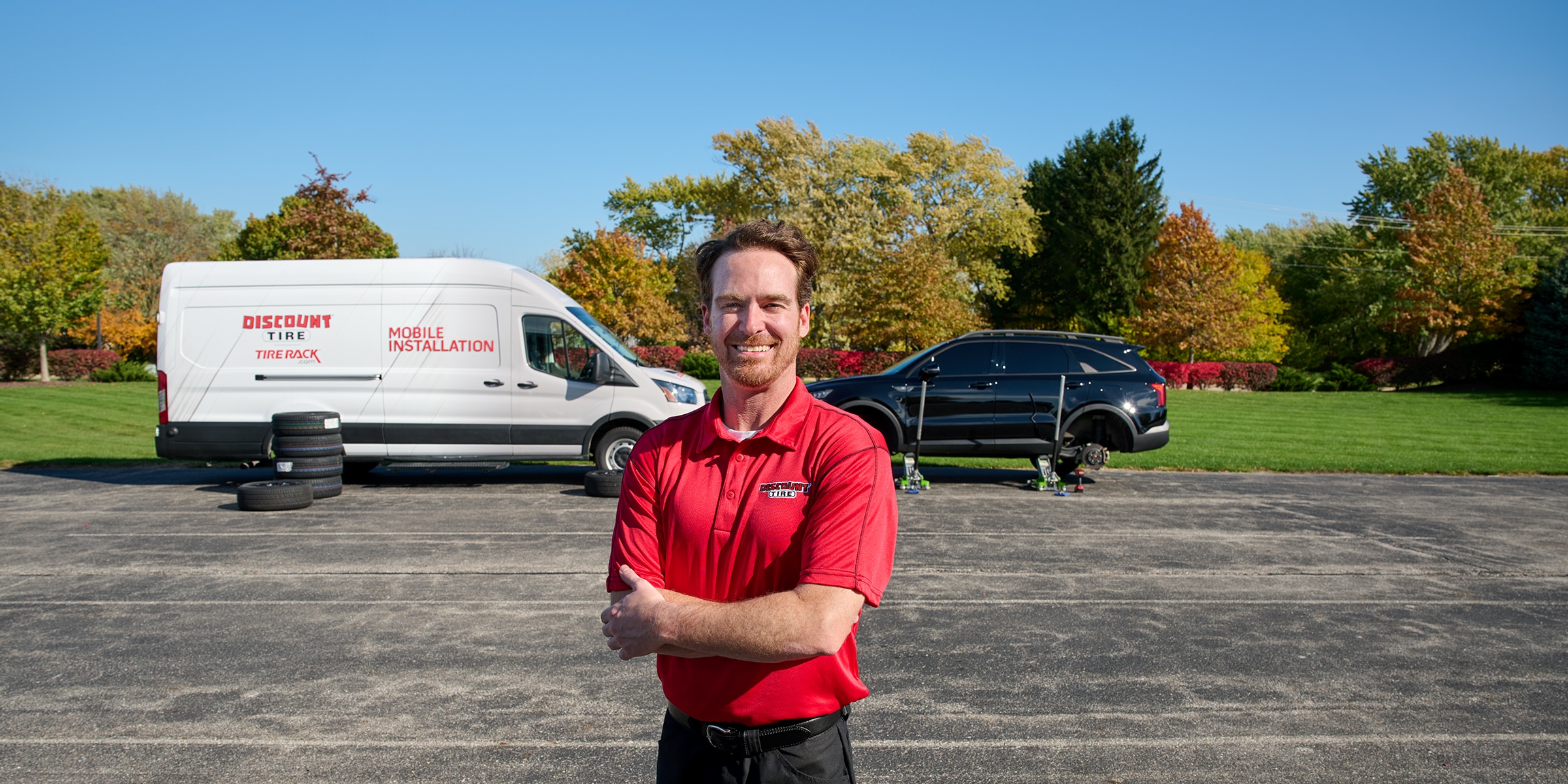 Discount Tire Mobile Installer standing in front of a DTMI Branded van.