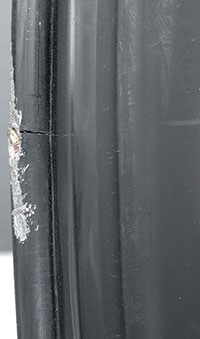 Black wheel with curb damage and bead flange crack