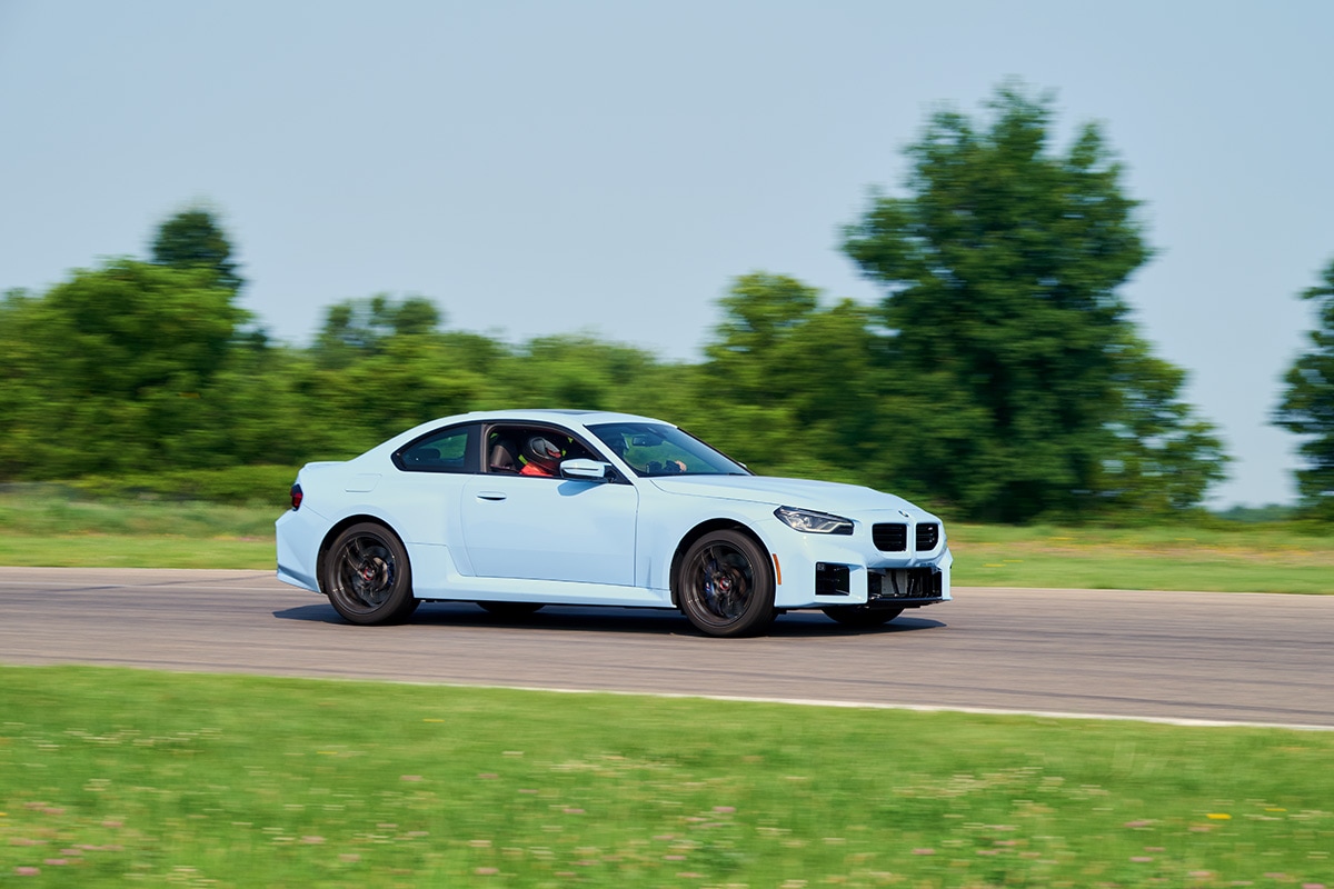 Light blue 2024 BMW M2 driving down the test track